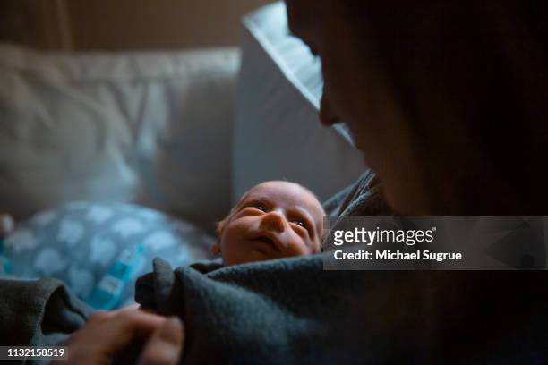 A mother tenderly holds her newborn baby at the hospital.
