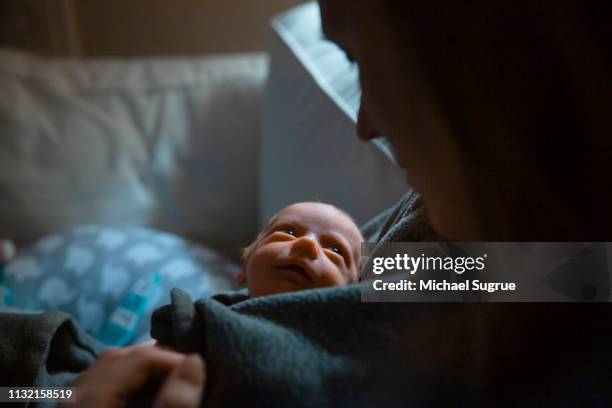 A mother tenderly holds her newborn baby at the hospital.