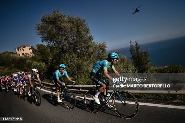 Belgium's Laurens De Vreese and the pack ride in the Cipressa ascent during the one-day classic cycling race Milan - San Remo on March 23, 2019.