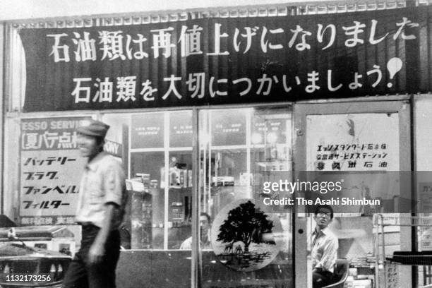 Banner calling for oil saving is displayed at a petrol station during the oil crisis of 1973-74, Japan, circa 1973.