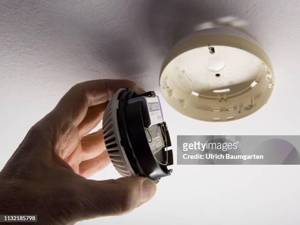 Symbol photo on the topics apartment fire, fire detector, smoke detector, fire protection, etc. The picture shows the installation of a smoke...