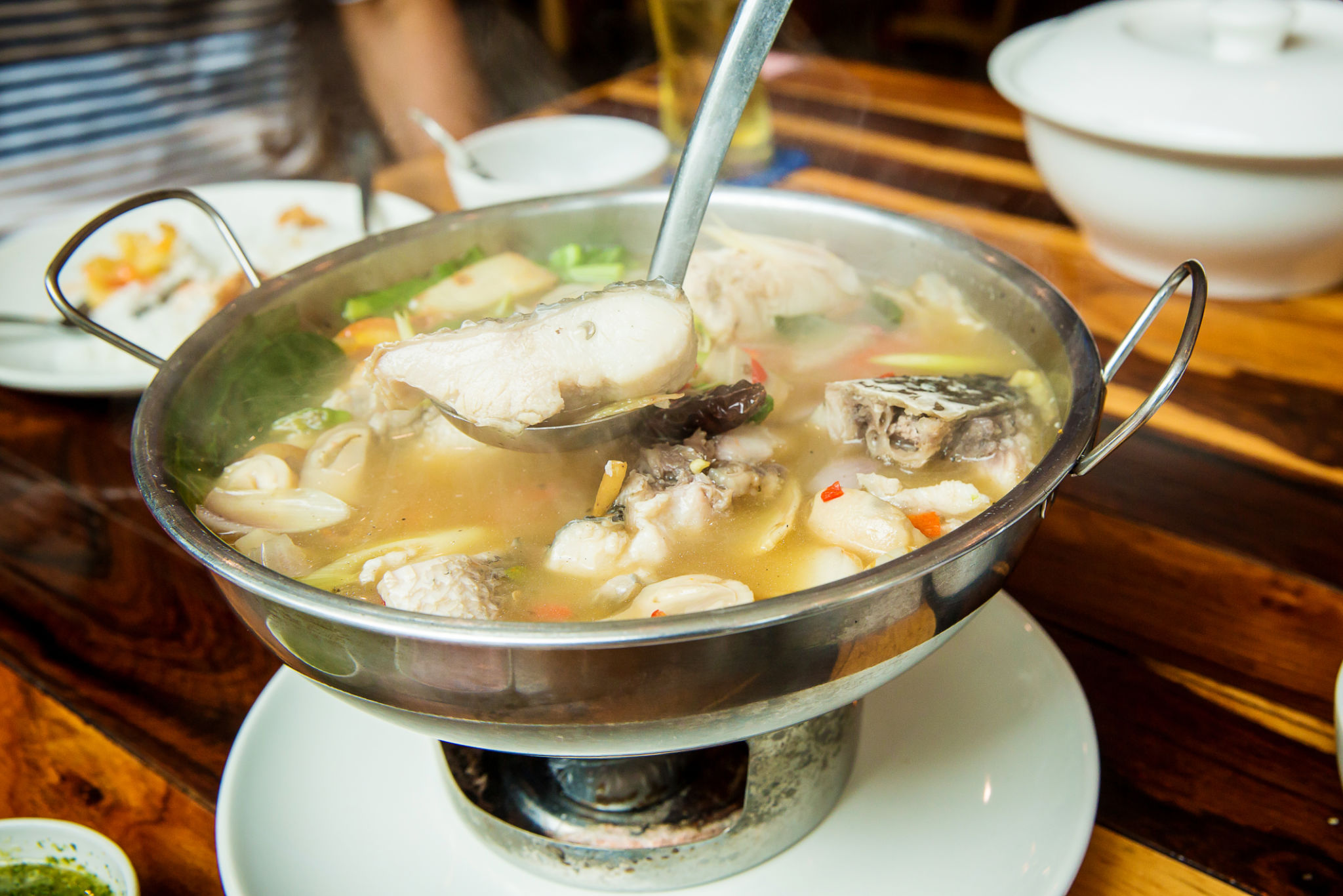 Thai spicy freshwater fish soup with herbs, served in big bowl. Tom Yam Pla. Thai famous street local food. Thai spicy freshwater fish soup with herbs, served in big bowl. Tom Yam Pla. Thai famous street local food.