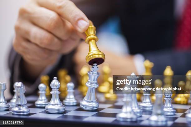 hand of businessman playing chess. - chess king piece stock pictures, royalty-free photos & images