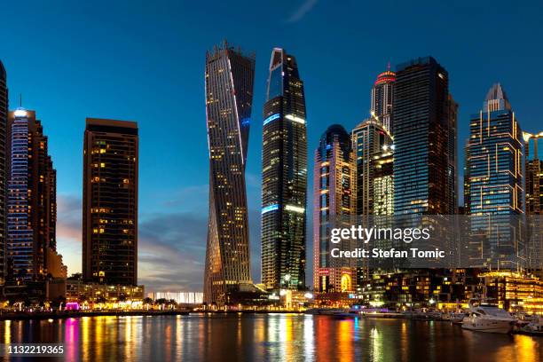 dubai marina skyscrapers and yachts at blue hour - dubai marina stock pictures, royalty-free photos & images