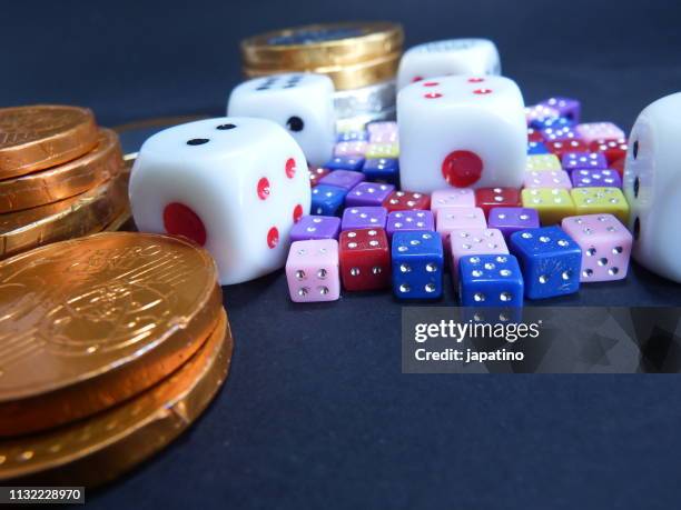 dice and euro coins of different sizes and colors - grupo de objetos stock-fotos und bilder