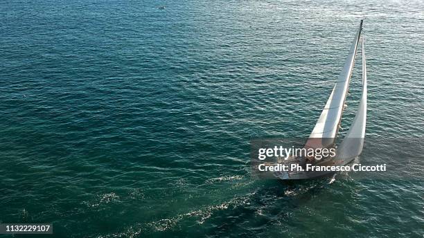 sailboat sailing on emerald sea - velista foto e immagini stock