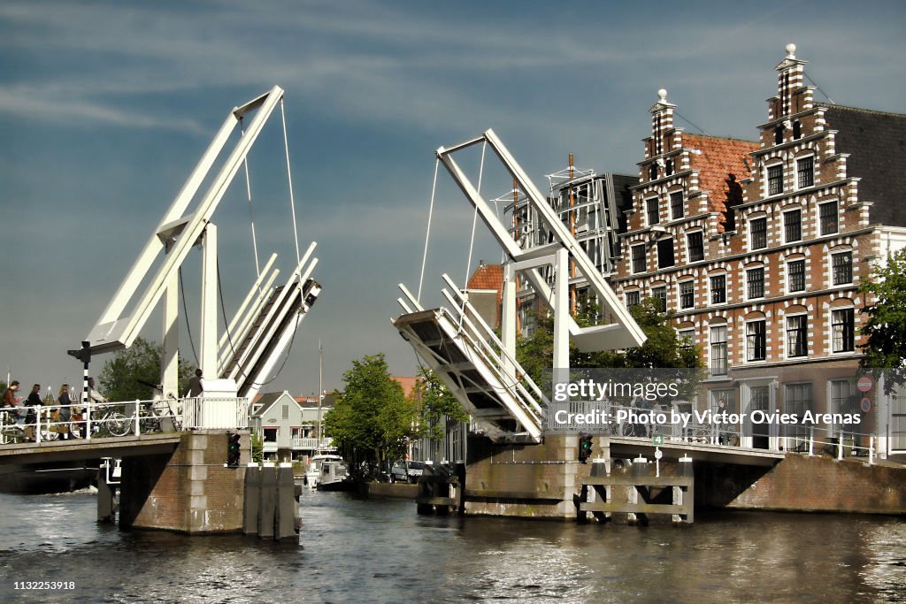 People waiting to cross over the Gravestenenbrug drawbridge lifted on the Spaarne River in Haarlem, Netherlands