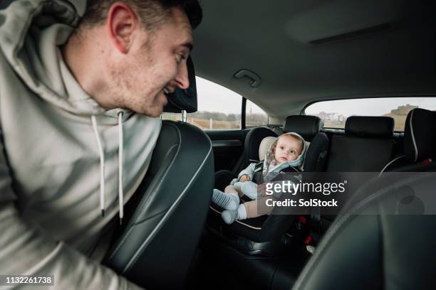 checking on the back seat driver - baby car seat stock pictures, royalty-free photos & images