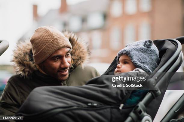 checking up on his baby son - pushchair stock pictures, royalty-free photos & images