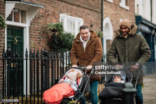 amigos masculinos con sus bebés en tynemouth, reino unido - group of friends walking along street fotografías e imágenes de stock