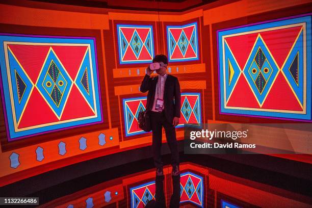 Visitor enjoys a Virtual Reality experience at the Saudi Telecom Company booth on day 2 of the GSMA Mobile World Congress 2019 on February 26, 2019...
