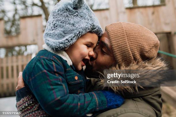 giving his son a kiss on the cheek - winter baby stock pictures, royalty-free photos & images