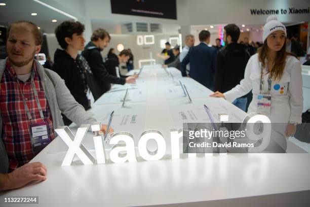 Visitors check devices at the Xiaomi booth on day 2 of the GSMA Mobile World Congress 2019 on February 26, 2019 in Barcelona, Spain. The annual...