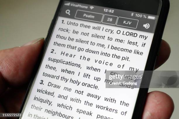 Bible on a smartphone. Man reading the New Testament. The psalms.