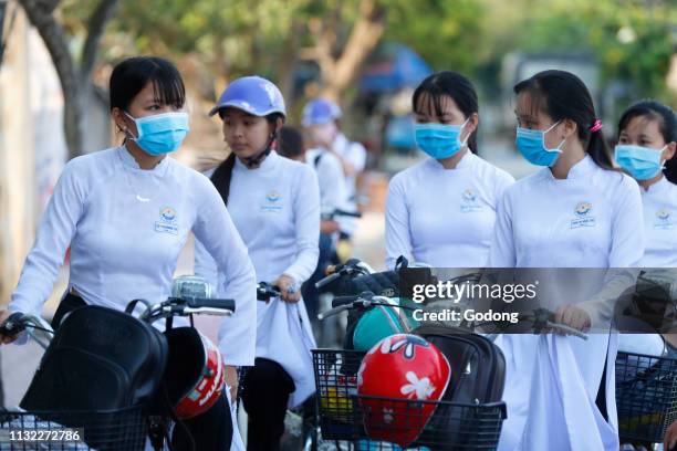 Students dressed in Ao Dai on the way to school. Cai Be. Vietnam.