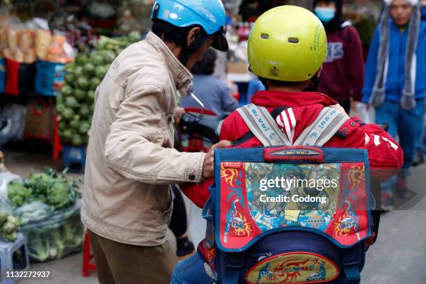 Father and son. On the way to school. Dalat. Vietnam.