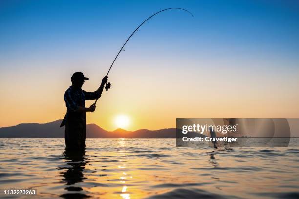 the silhouette fishing man, once of thailand tradition,asia. - fishing ストックフォトと画像