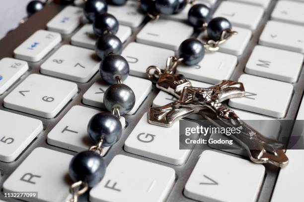 Christian Rosary on a white computer keyboard.