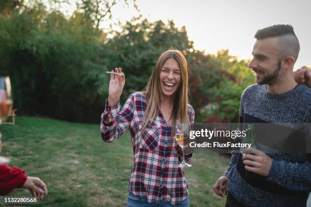 fröhliche menschen rauchen marihuana-joint auf einer party - human joint stock-fotos und bilder