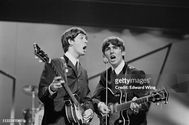 British musicians Paul McCartney and George Harrison of the Beatles performing on stage at the London Palladium, UK, 13th October 1963.