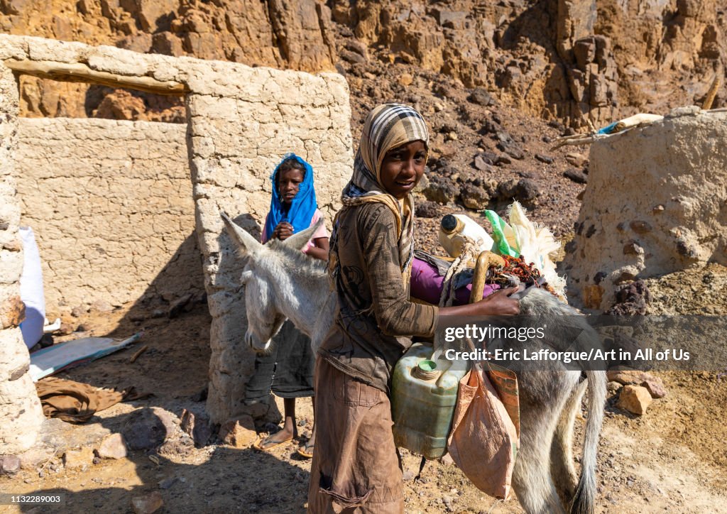 Bisharin nomad girls collecting salt in Atrun crater, Bayuda desert, Atrun, Sudan...