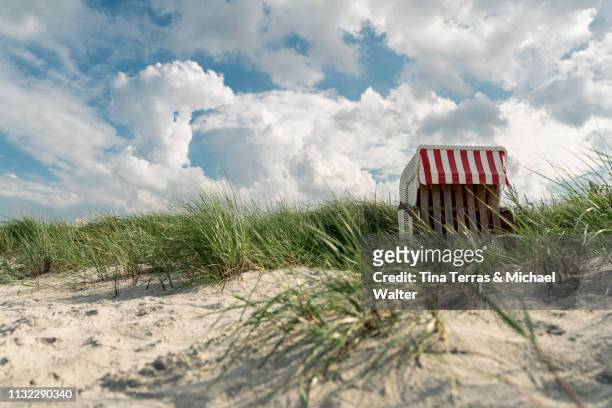 closed hooded beach chair in the dune at the baltic sea (strandkorb) - wolkengebilde stockfoto's en -beelden