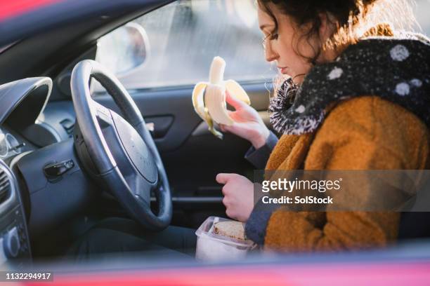 quick car lunch - woman eating fruit stock pictures, royalty-free photos & images