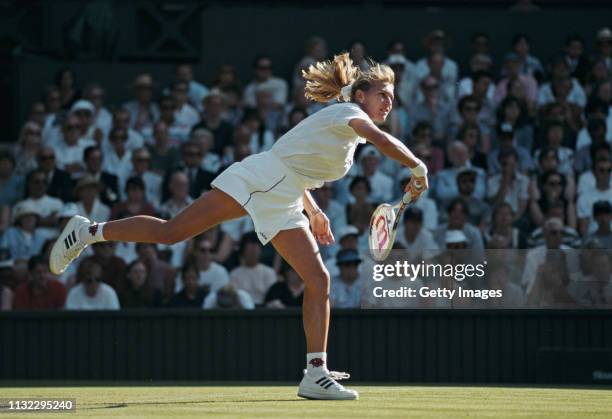 Steffi Graf of Germany makes a serves during the Women's Singles First Round defeat of Martina Hingis of Switzerland during the Wimbledon Lawn Tennis...