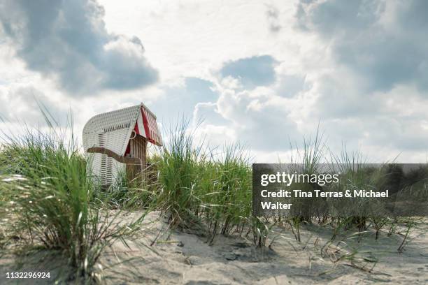 closed hooded beach chair in the dune at the baltic sea (strandkorb) - wolkengebilde stockfoto's en -beelden