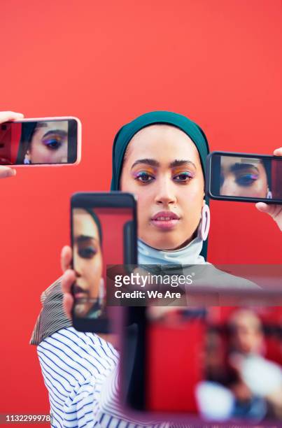young woman surrounded by smartphones. - woman selfie portrait stock pictures, royalty-free photos & images
