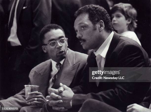 Filmmaker Spike Lee, left, and the Rev. Jesse Jackson sit side-by-side at the New York Knicks basketball game at Madison Square Garden in Manhattan...