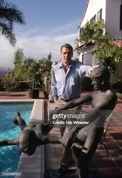 Film actor Rock Hudson with metal sculpture beside his pool in the garden of his home in Beverly Hills before his death from AIDS in 1985