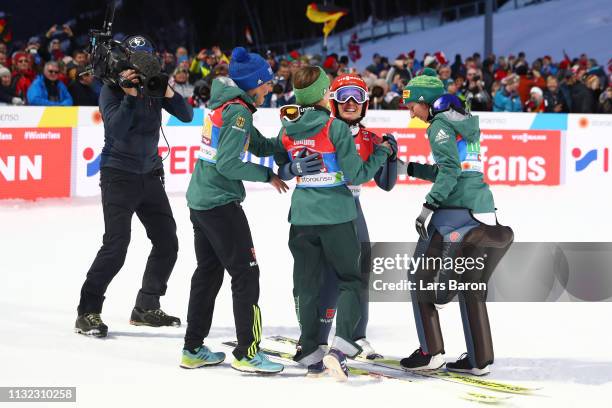 Katharina Althaus of Germany celebrates with team mates Ramona Straub, Juliane Seyfarth and Carina Vogt after winning the HS109 women's ski jumping...