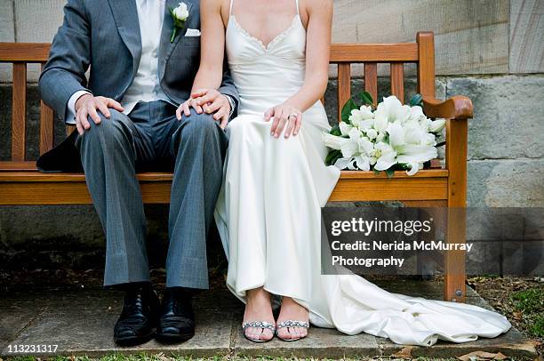 bride and groom on bench - bride and groom stock-fotos und bilder