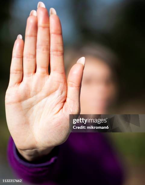 midsection of woman gesturing stop sign - hand stop stock-fotos und bilder