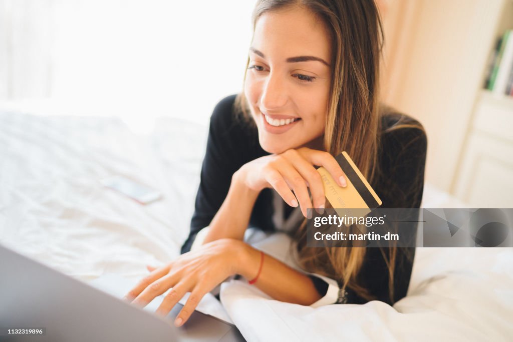 Woman in bed shopping online