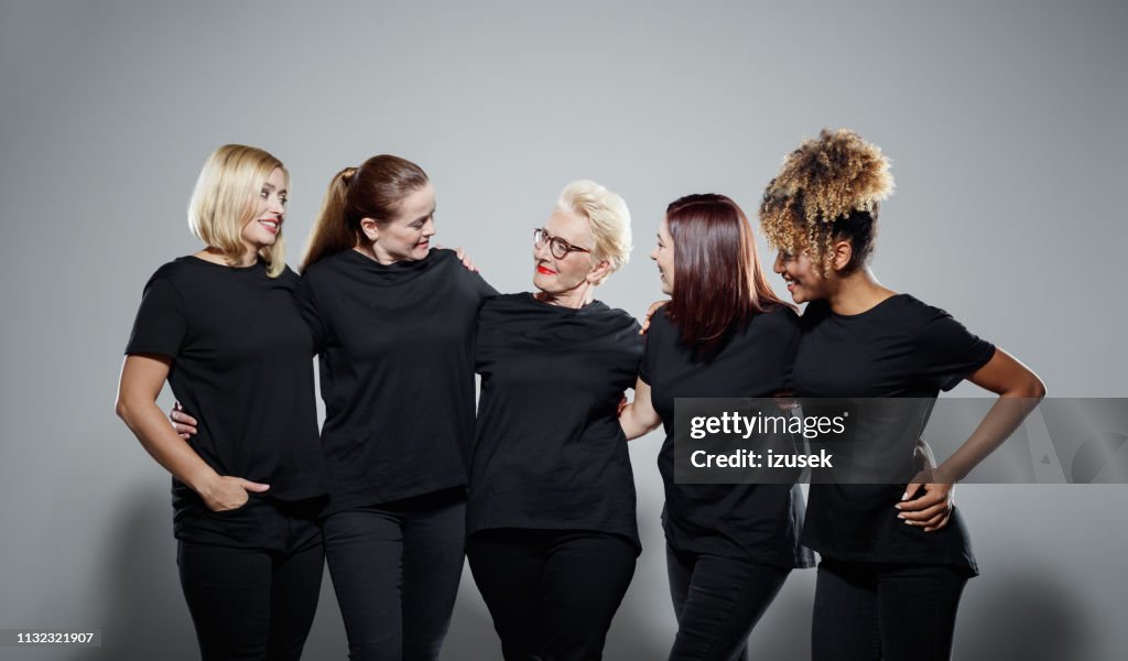 Lächelnde multiethnische Frauen, die schwarze Kleidung tragen