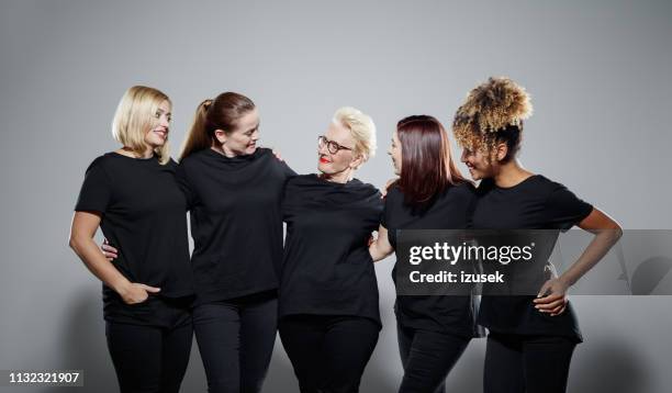 glimlachende multi-etnische vrouwen het dragen van zwarte kleren - t shirt stockfoto's en -beelden