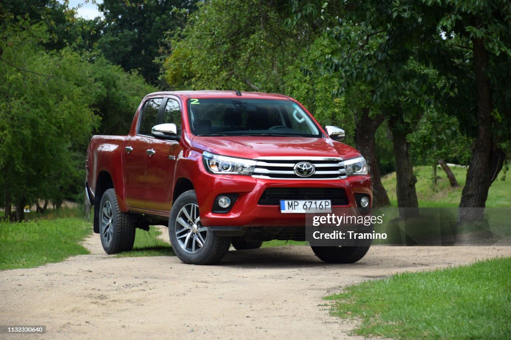 Red pick-up Toyota Hilux on the road