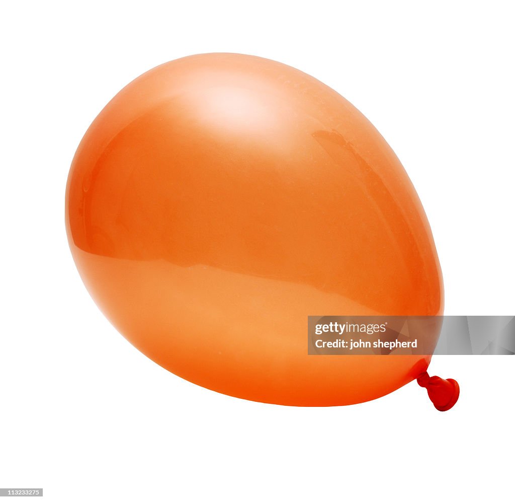 Orange inflated party balloon isolated against white