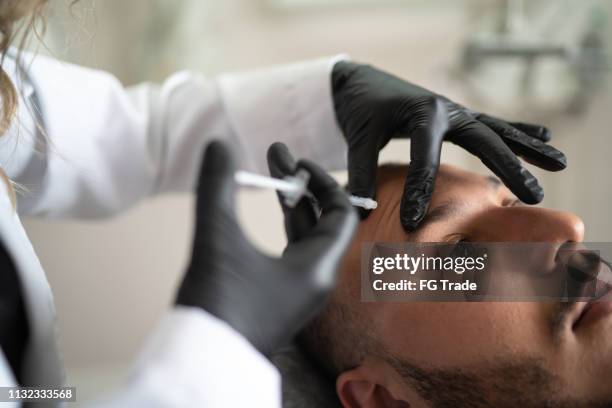 filler injection for male face in beauty clinic - face mask protective workwear imagens e fotografias de stock