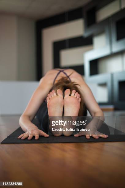 woman stretching body on mat - adult gymnast feet stock-fotos und bilder