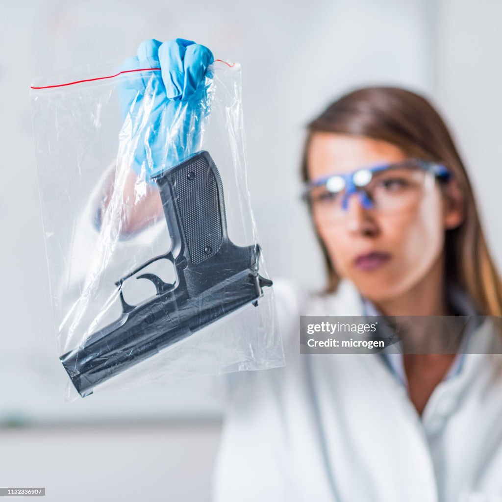 Labgun Female Scientist Holding Gun In Plastic Bag In Laboratory High-Res ...