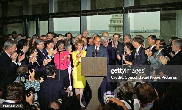 American politician US Senate Majority Leader Bob Dole smiles from the podium during a press conference to announce his resignation from the Senate...