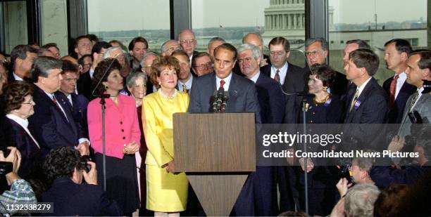 American politician US Senate Majority Leader Bob Dole smiles from the podium during a press conference to announce his resignation from the Senate...