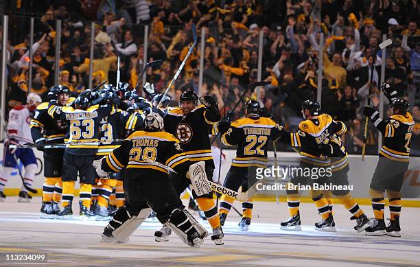 Tim Thomas of the Boston Bruins celebrates with Johnny Boychuk after the overtime win against the Montreal Canadiens in Game Seven of the Eastern...