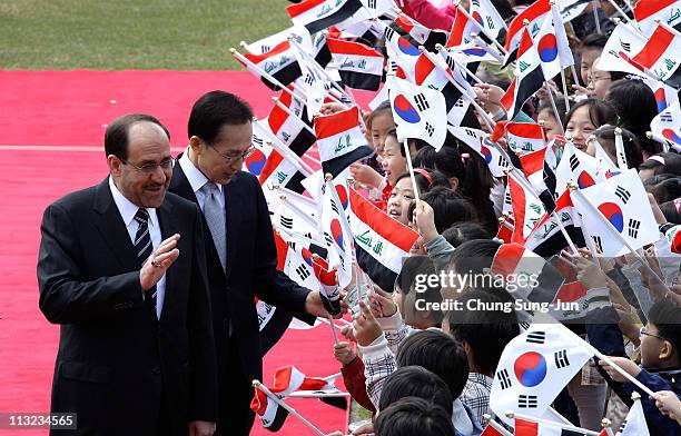 Iraqi Prime Minister Nouri al-Maliki and South Korean President Lee Myung-Bak greet South Korean children during a welcoming ceremony held at the...