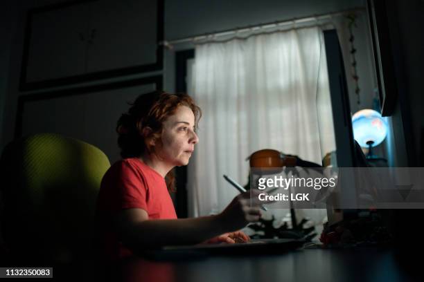 a woman works on her computer at her home office - showus work stock pictures, royalty-free photos & images