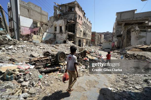 November 21 2018. Children walk by bombed-out buildings on November 21, 2018 in Aden, south Yemen.