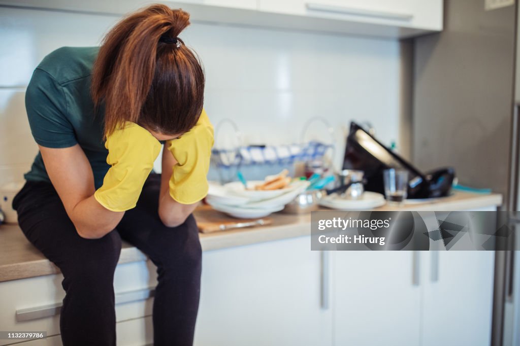 ストレスのある主婦は台所に座っている